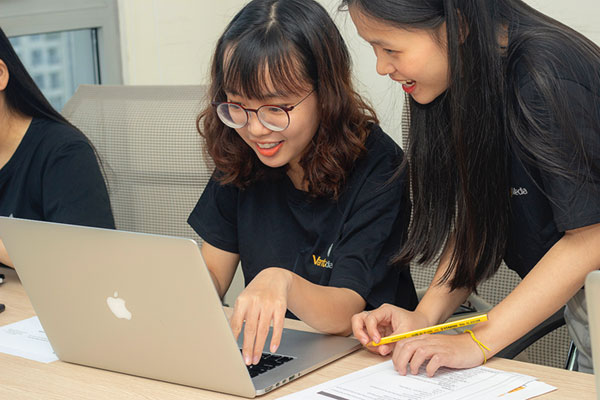 Two students working on a laptop together